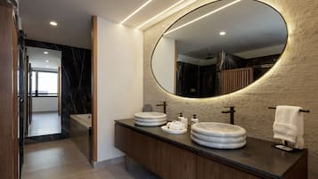 A modern bathroom with a large mirror, two sinks, and a towel rack.