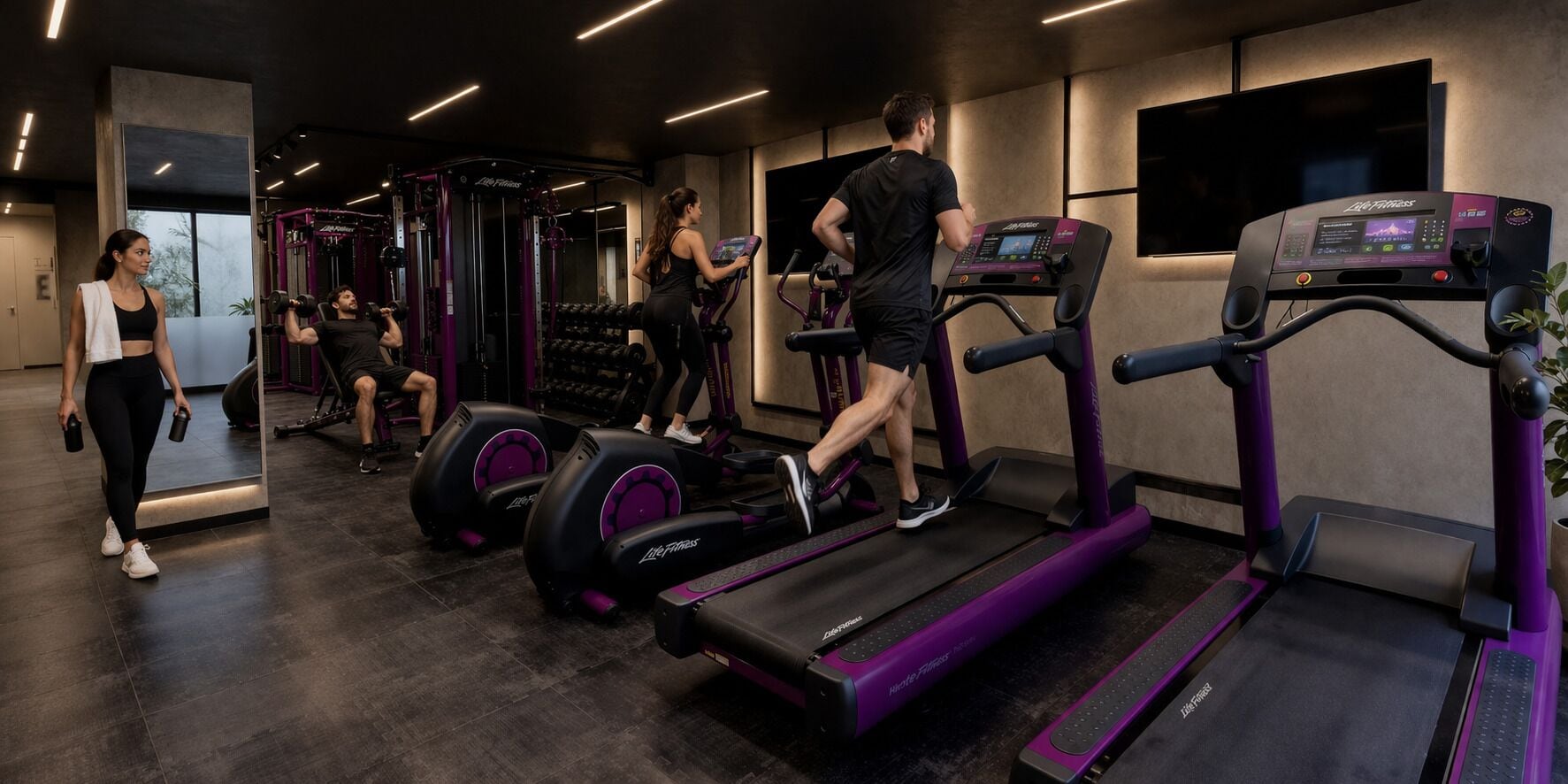 Une salle de sport équipée de tapis de course, d’appareils de musculation et d’haltères.