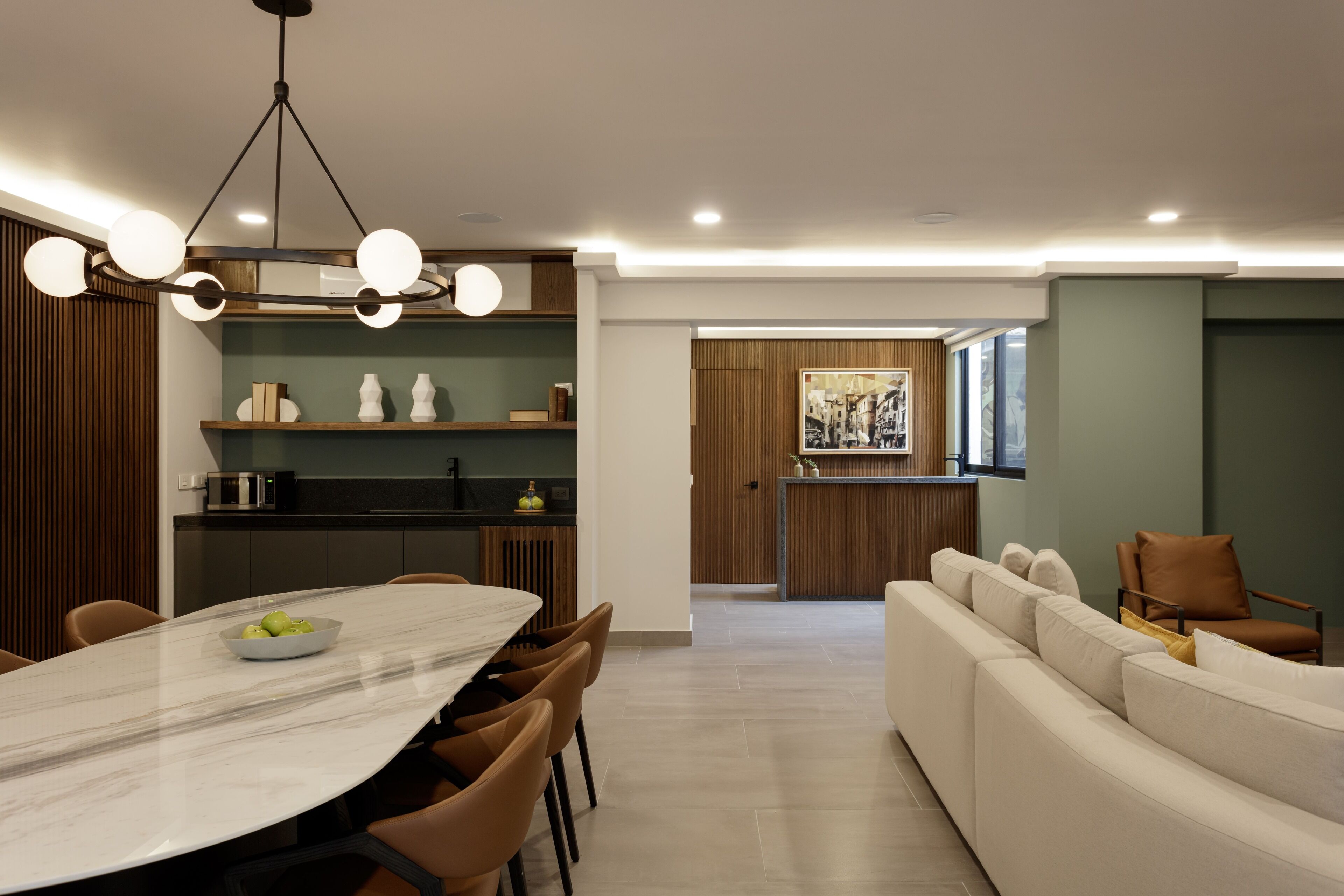 Una cocina moderna con comedor, que incluye una mesa de mármol, sillas marrones y una lámpara contemporánea.