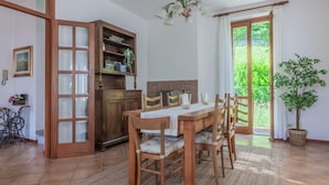 A dining area with a wooden table, chairs, and a buffet cabinet. - Villa Gard by Wonderful Italy (Bellagio)