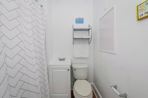 Bathtub, hair dryer, towels, shampoo