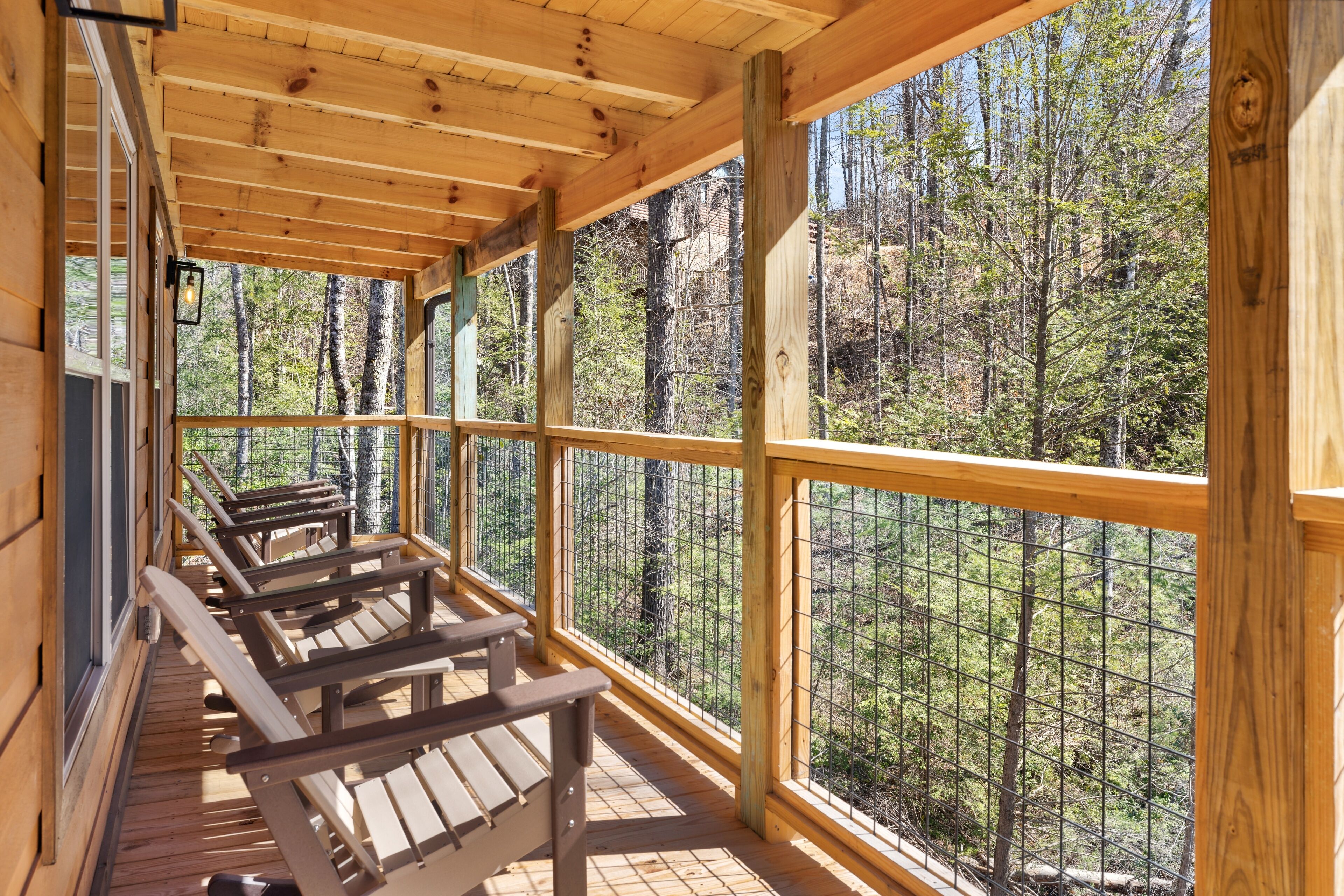 Une terrasse en bois avec des bancs donnant sur une zone boisée.