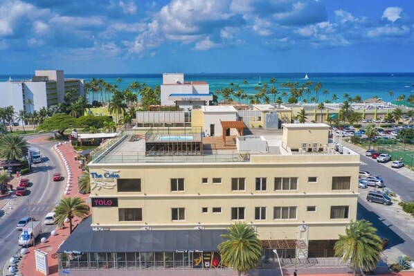 A hotel with a rooftop pool, a sign for 'The Cove', and a view of the ocean.
