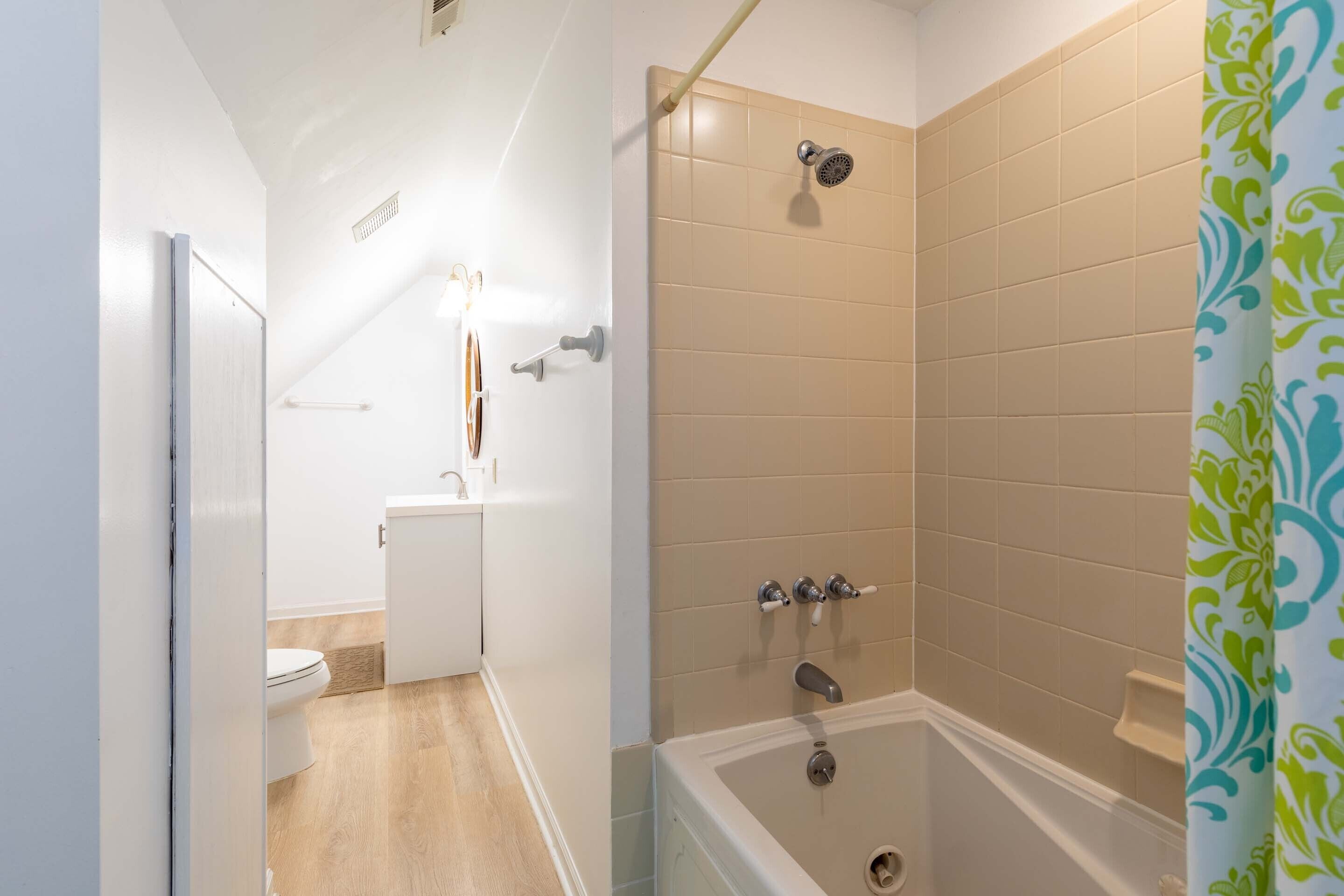 A bathroom with a shower, toilet, and sink.