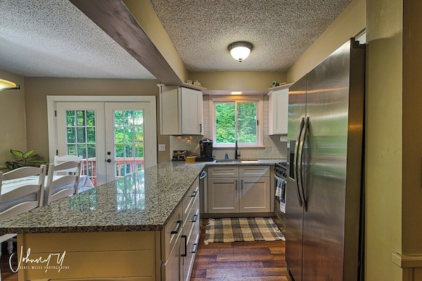 The kitchen has been completely updated, including granite countertops, a workstation sink, and stainless steel appliances (including a dishwasher not shown). The kitchen comes fully stocked with pots and pans, cooking utensils, silverware, etc.