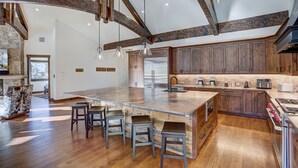 A spacious kitchen with a large island, wooden beams, and modern appliances. - Bear Tracks 18 (Keystone)