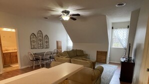 A spacious living area with a ceiling fan, a dining table with chairs, a sofa, and a TV stand. - Cozy, 1-bedroom apartment, 11 miles to campus (Oxford)