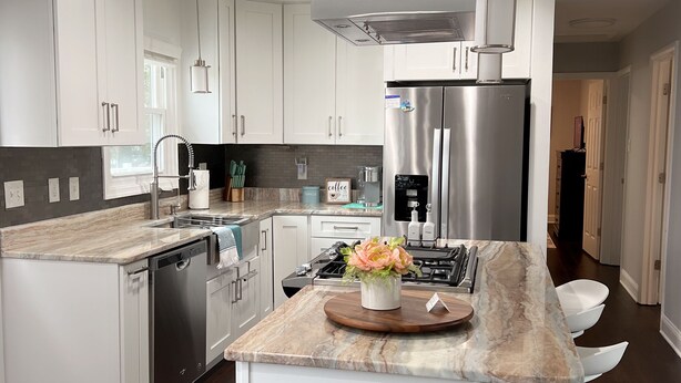 A modern kitchen with white cabinets, a stainless steel refrigerator, a built-in oven, and a marble countertop. - Alexandria VA spacious, family-friendly 5BR Home near DC (Alexandria)