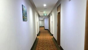 A hotel hallway with carpeted floors, white walls, and doors on both sides. - Greentree Inn Jiangsu Changshu Longying Plaza Express Hotel (Suzhou)
