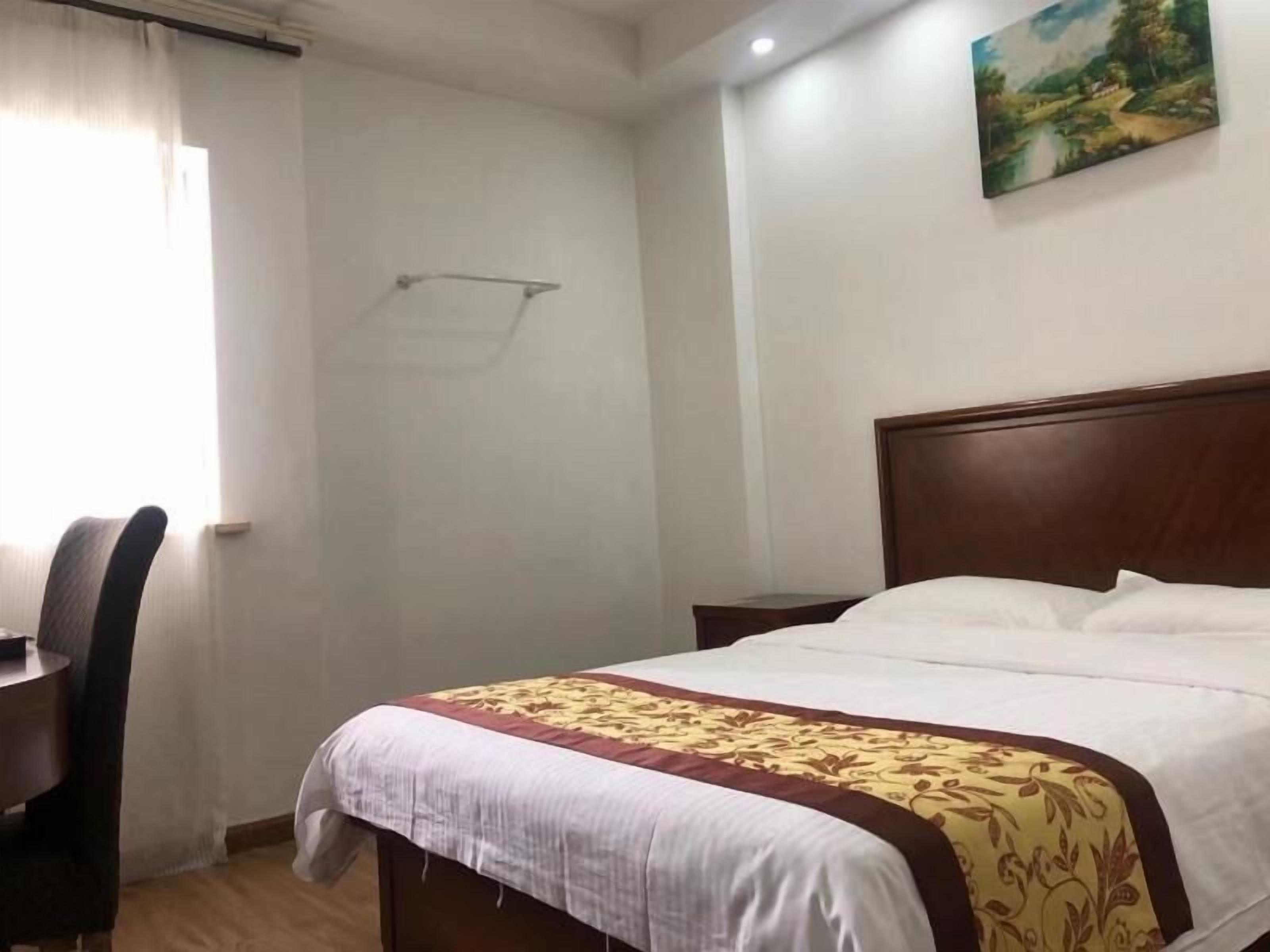 Una habitación de hotel con una cama de madera, un escritorio y una silla.