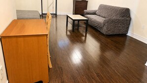 Ein Zimmer mit einem Holztisch, einem grauen Sofa und einem kleinen Tisch.