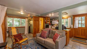 A cozy living room with a sofa, rocking chair, and a patterned rug.