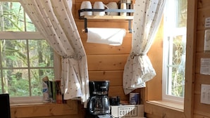 Cocina compacta con cafetera, microondas y refrigerador.