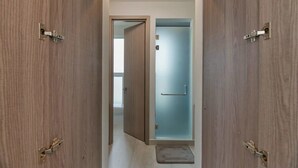 A hallway with wooden doors, a glass shower door, and a visible bathroom door. - Mantaray Villa #6 Sum (roatan)