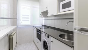 A modern kitchen with a built-in oven, microwave, and sink.