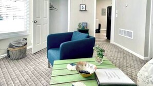 A room with a blue sofa, a green coffee table, and a patterned carpet. - Completely remodeled efficiency unit one block from the Smithville square (Smithville)