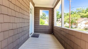 A covered porch with a view of a residential neighborhood. - Modern and comfy home five minutes from downtown (Hannibal)