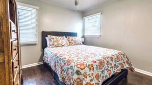 A bedroom with a bed, a ceiling fan, and a dresser. - Great for a staycation, or work-from-home alternative (Kansas City)