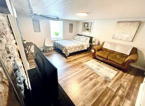 Cozy retreat with a comfortable bed, sofa, and table, perfect for relaxing.