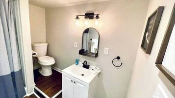 Ein Badezimmer mit Toilette, Waschbecken und Spiegel.