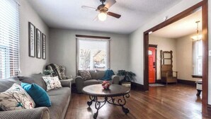 A living room with a sofa, a round coffee table, and a ceiling fan. - Spacious five-bedroom home in the heart of Kansas City - Fast highway access (Kansas City)