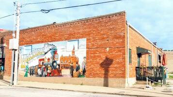 Edifici de maó amb un mural que representa una escena històrica.