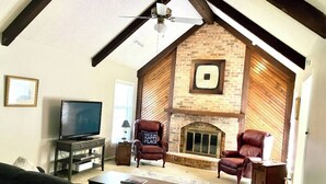 A living room with a fireplace, leather armchairs, a television, and a ceiling fan. - The Bird House has at least one ‘bird’ in each room. How many can you find? (Kansas City)