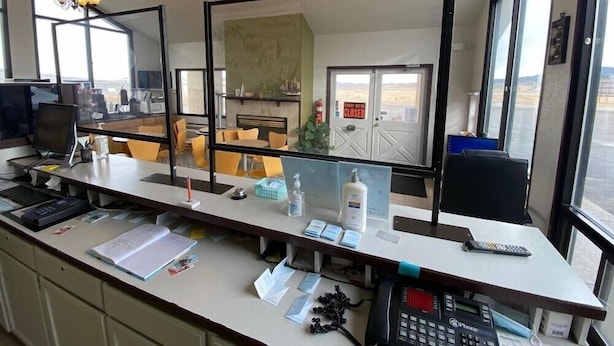 A modern office with a large desk, multiple monitors, a phone, and a large mirror. - Super 8 by Wyndham Wells (Wells)