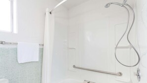 A bathroom with a shower, a toilet, and a grab bar. - Super 8 by Wyndham Wells (Wells)