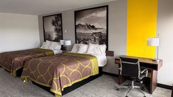 A hotel room with two beds, a desk, and a chair.