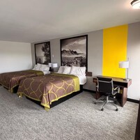 Una habitación de hotel con dos camas, un escritorio y una silla.