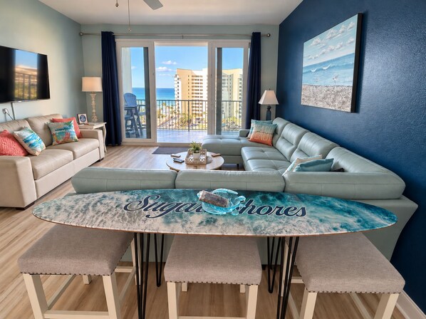 A living room with a sofa, a coffee table, and a dining area with benches.