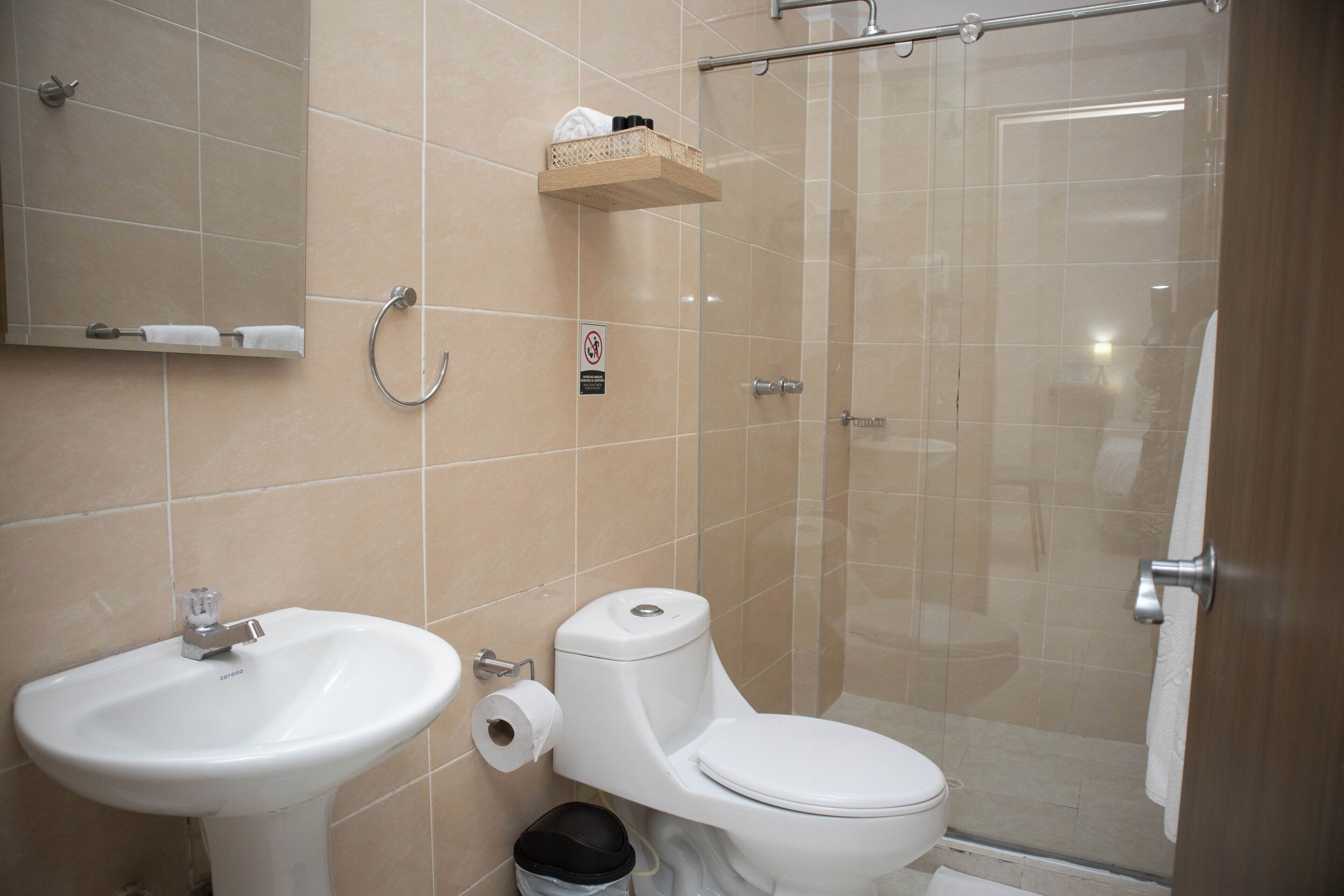 A bathroom with a sink, toilet, and glass shower enclosure.
