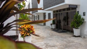 A reception area with a sign, potted plants, and a pathway leading to a building. - Hotel El Marques de Manga (Cartagena)