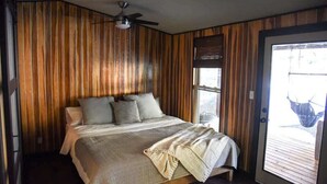A bedroom with a bed, a ceiling fan, and a door leading to an outdoor area. - Mountain Zen (Alto)