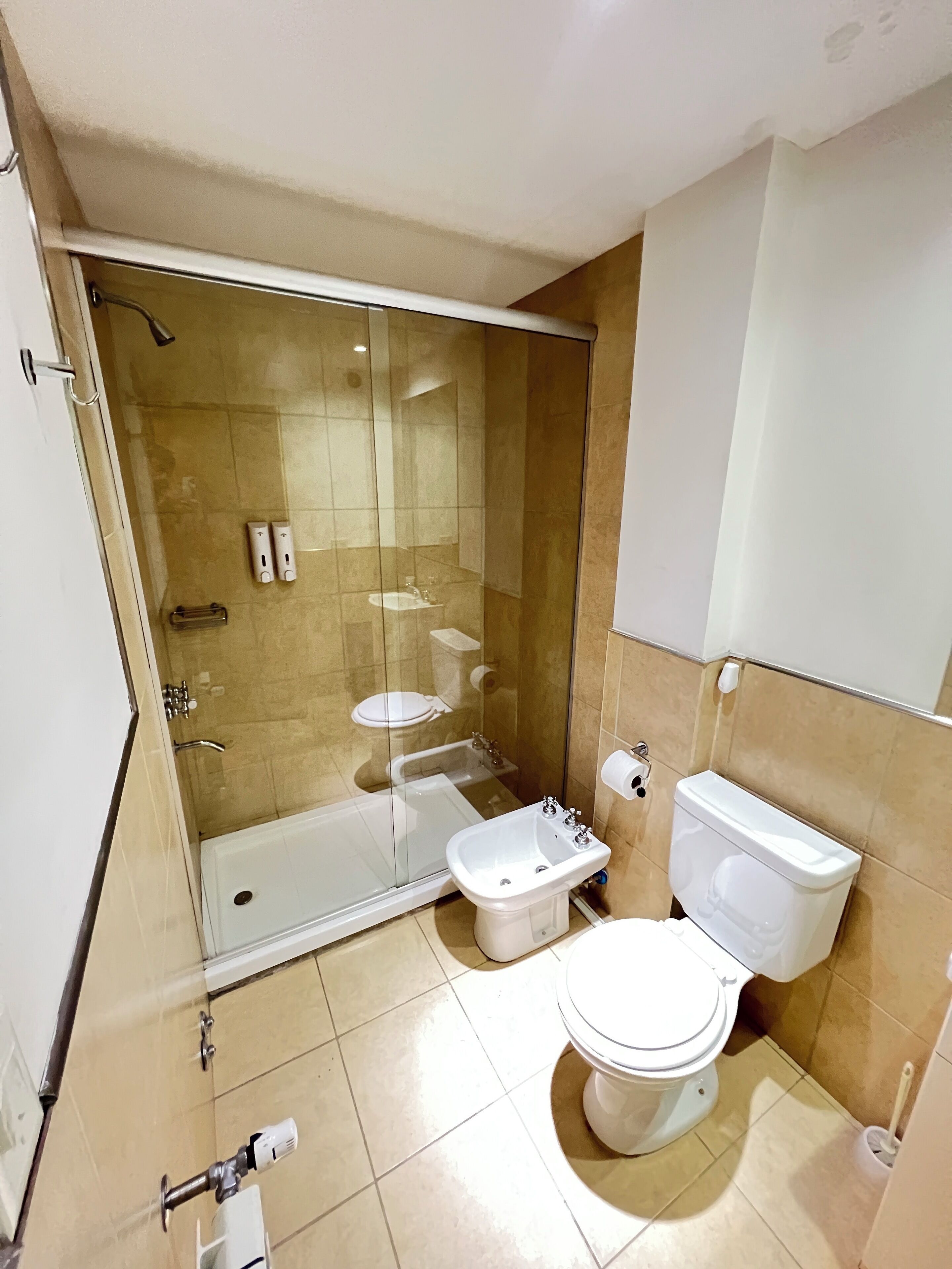 Ein modernes Badezimmer mit einer Duschkabine, einer weißen Toilette und einem Bidet.