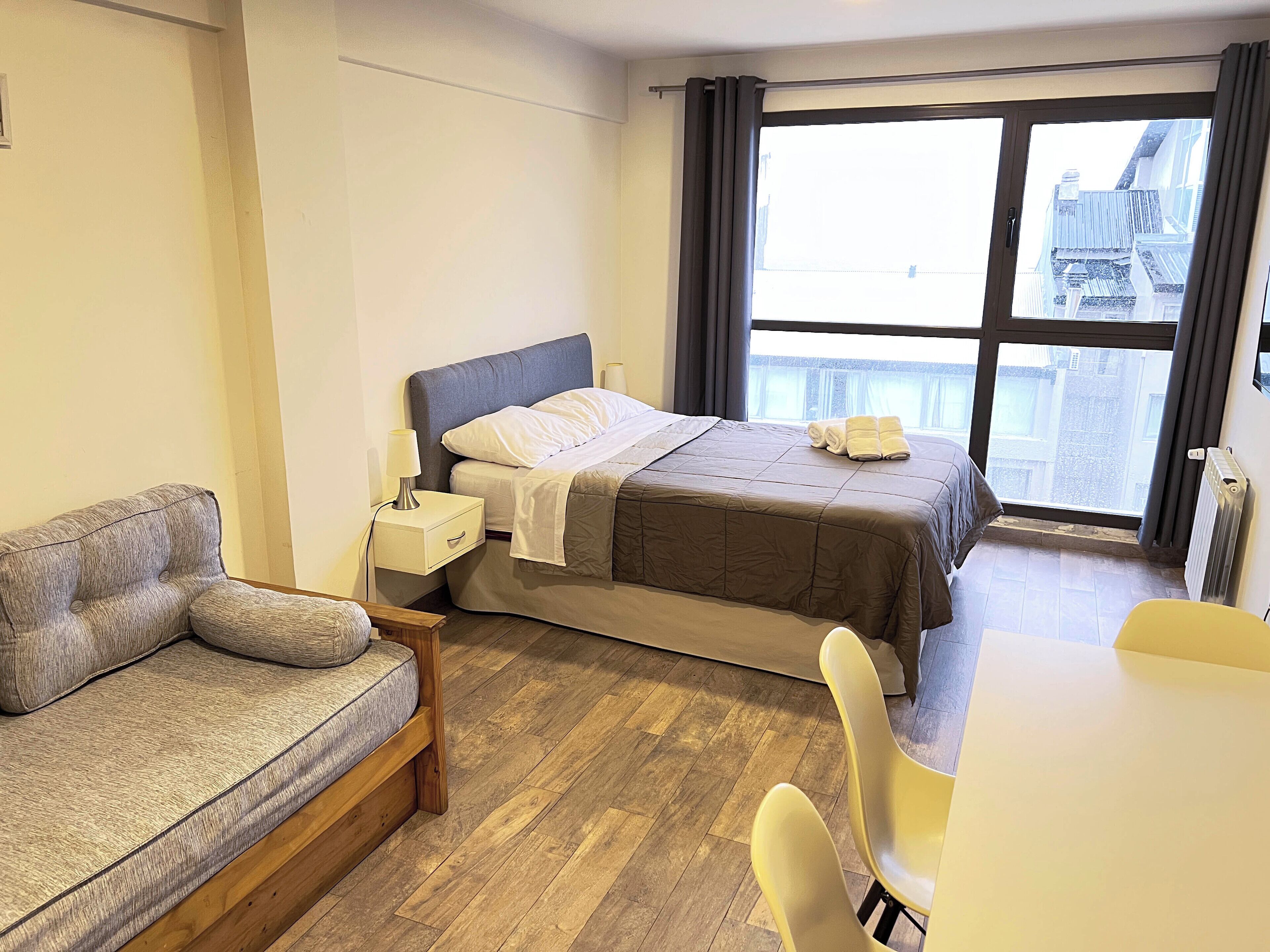 Una habitación de hotel con una cama, un sofá, una mesa y una silla.