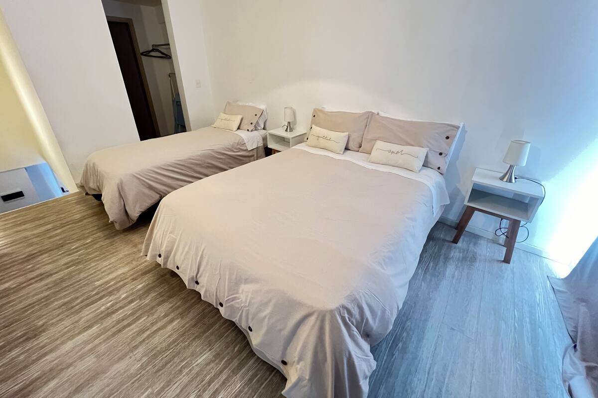 Habitació doble amb dos llits, cadascun amb nínxols a joc i una taula de nit amb una làmpada.