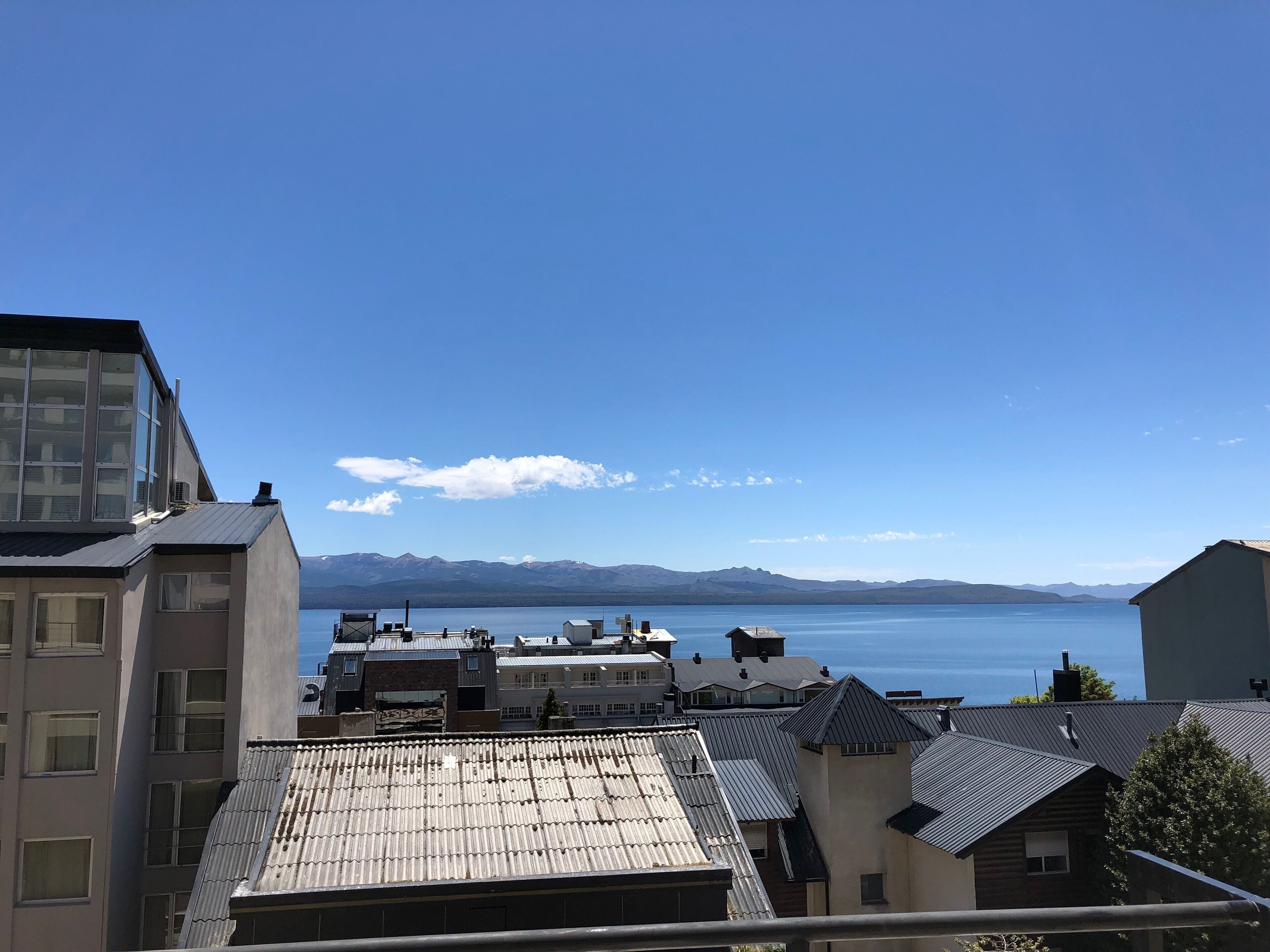 Zona residencial com vista para um lago e montanhas ao longe.