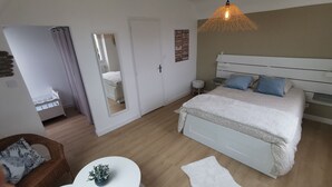 Ett sovrum med en säng, ett sängbord och en hängande lampa.