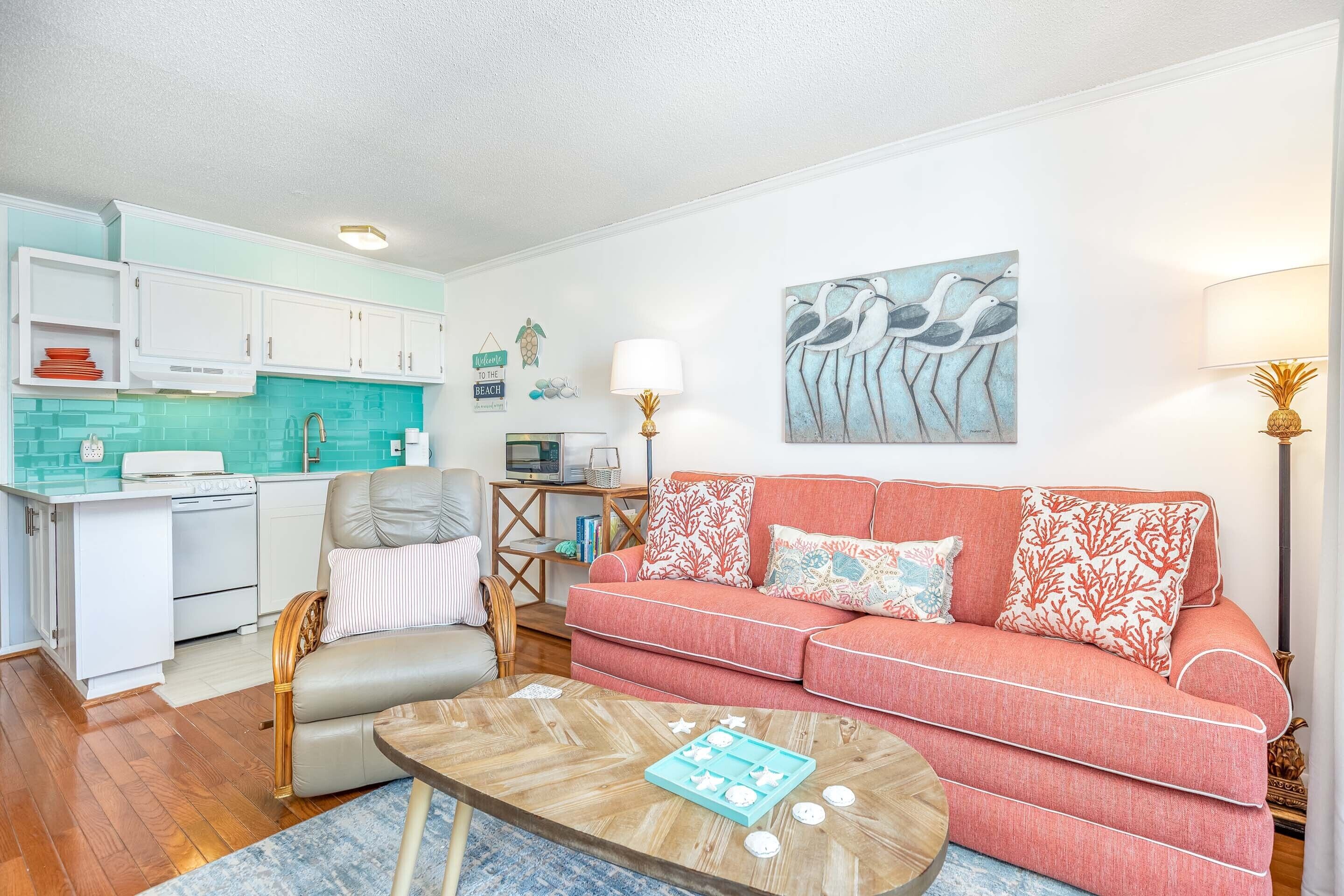 A compact living space with a kitchenette, a sofa, a coffee table, and a dining area.