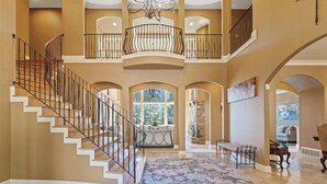 A spacious interior with a grand staircase, multiple balconies, and a central chandelier. - Beautiful Country Villa on 5 acres, 5 miles to downtown (Spokane)