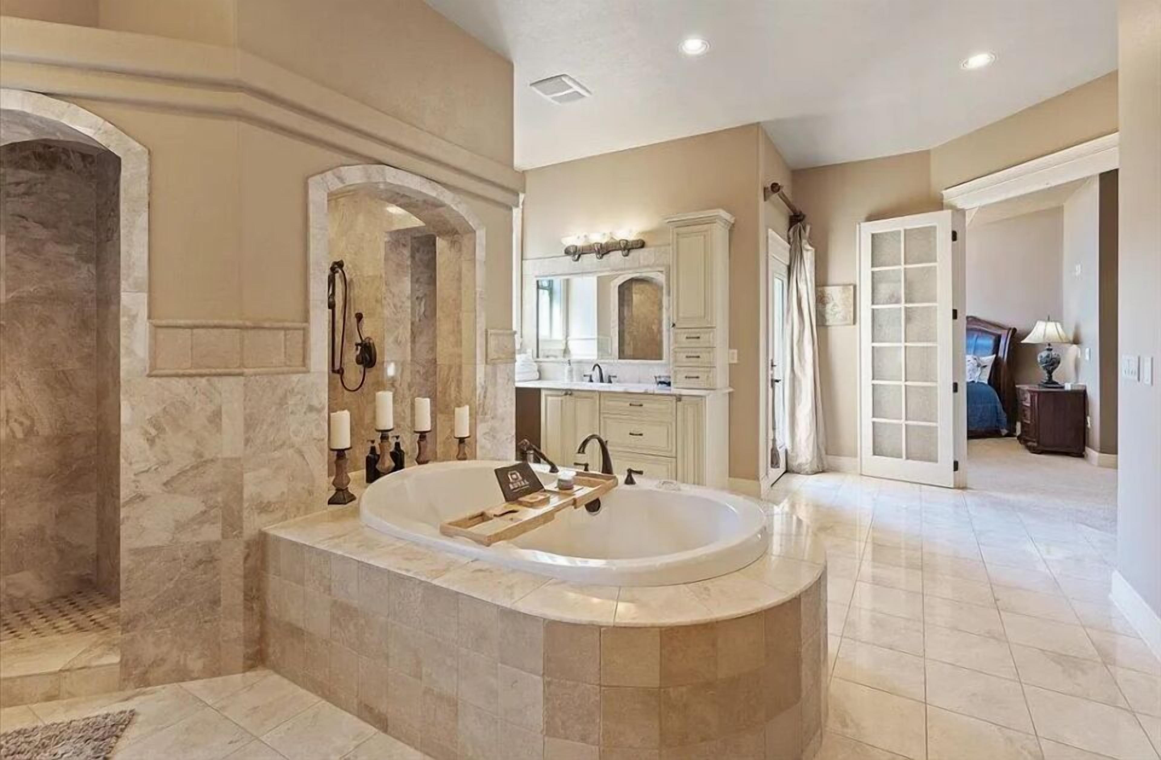 A spacious bathroom with a large freestanding bathtub, a vanity with a mirror, and a walk-in shower.