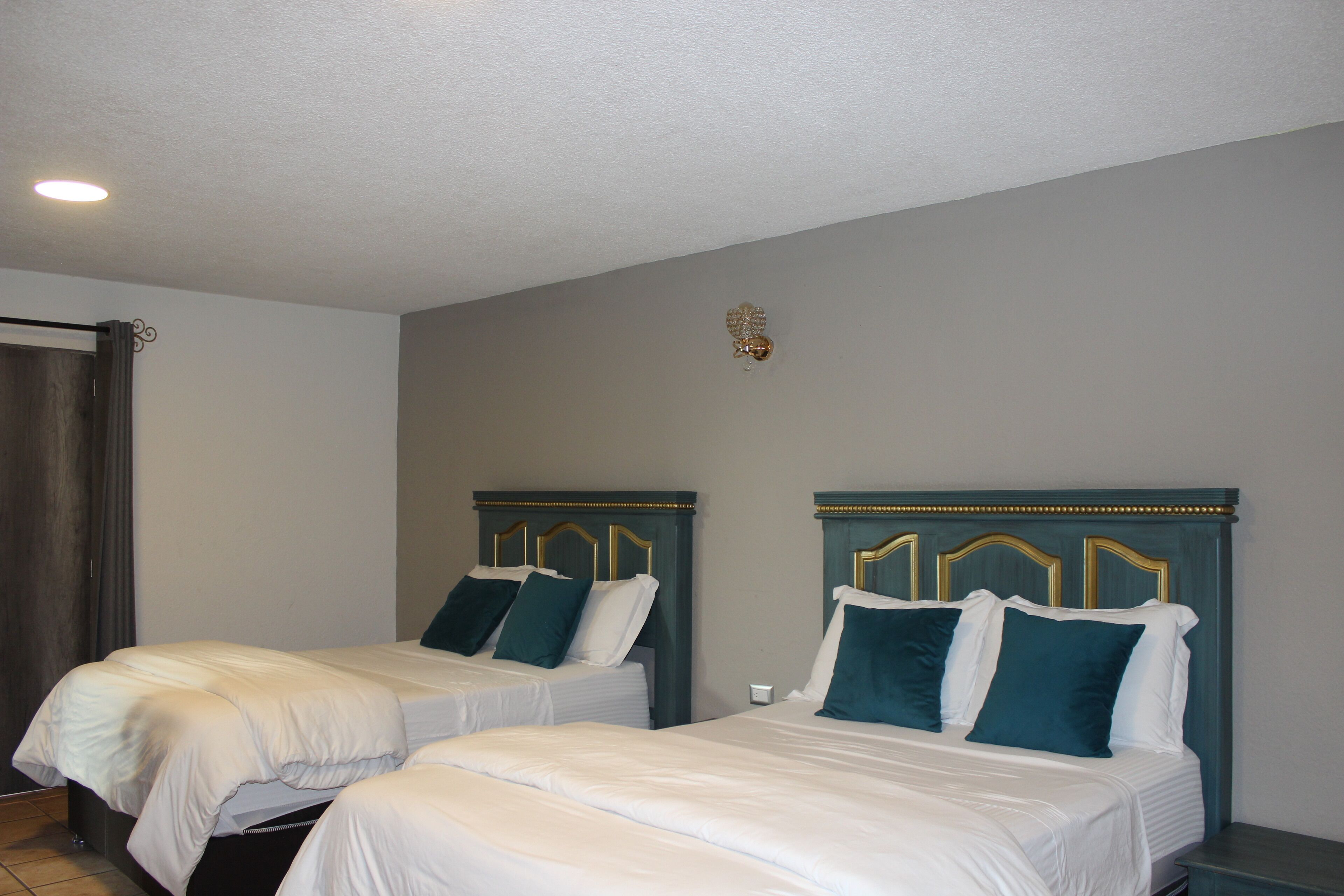 Een hotelkamer met twee bedden, elk met hoofdeinde en kussens.