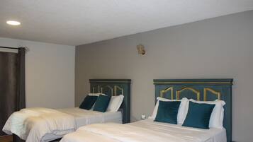Een hotelkamer met twee bedden, elk met hoofdeinde en kussens.