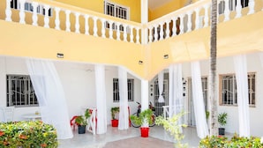 A multi-level courtyard with yellow walls, white railings, and potted plants. - Hermosa Suites n the heart of Punta Cana (Punta Cana)