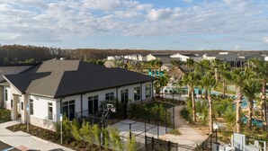 Zona residencial amb cases modernes, una piscina i una pista de bàsquet tancada per una reixa.