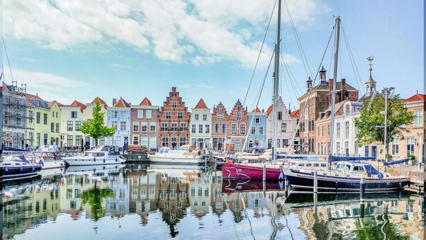A marina with boats docked, surrounded by colorful buildings with traditional architecture. - 2 bedroom stunning home in Heinkenszand (Heinkenszand)