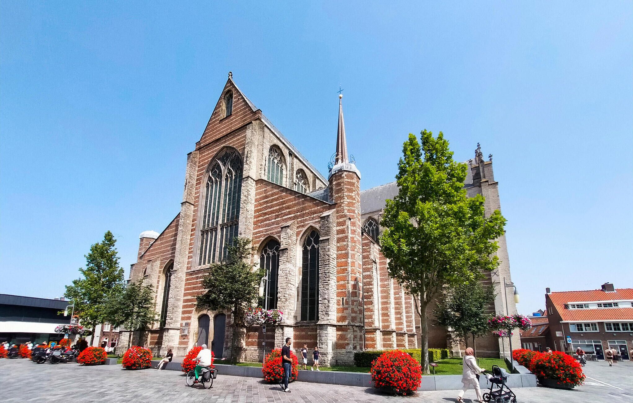 Una iglesia histórica con una aguja alta y amplias ventanas de arco.