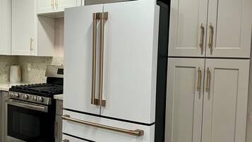 A kitchen with a white refrigerator, stainless steel oven, and a gas stove.